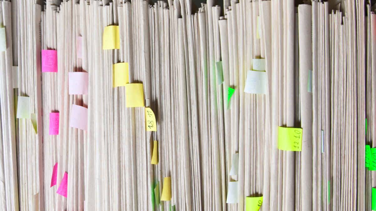 Stack of paper files ready to be digitized. 